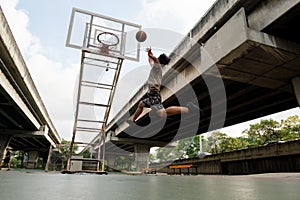 Two caucasian men pratice baskegball in court at urban street