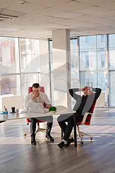 Two Caucasian men solve problems at work.