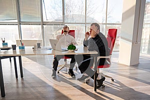 Two Caucasian men solve problems at work.