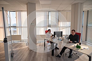 Two Caucasian men working in an office.