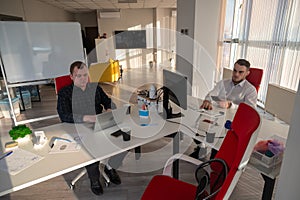 Two Caucasian men working in an office.