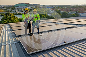 Two Caucasian technician workers stand on rooftop and discuss about the maintenance solar cell panels on rooftop of factory or the