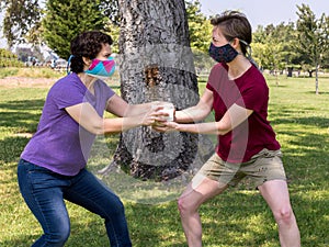 Two Caucasian women fighting over a roll of toilet paper at a park