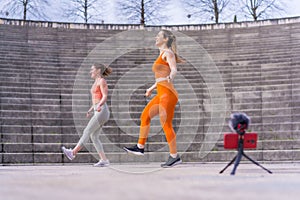 Two caucasian women jumping ropes while recording the exercise