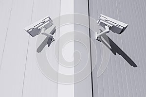 Two CCTV cameras in different directions at the corner of the building to control objects