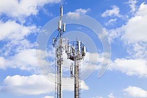 Two cell towers against the blue sky with clouds. Mobile communications and communications.