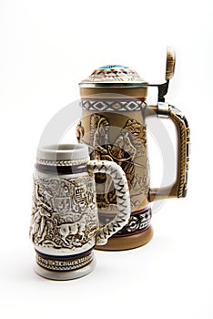 Two ceramic german beer mugs on a white background