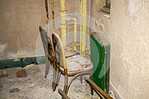Two Chairs Covered in Dust and Debris inside an Abandoned Building