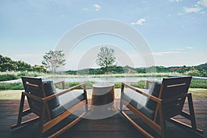 Two chairs for relaxing with deep green mountains and clear blue sky view