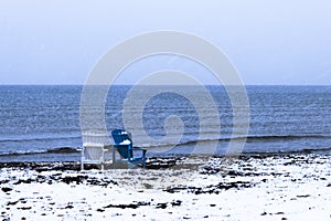 Two chairs on a snowy beach