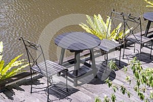 Two chairs and table on the backyard in tropical garden near lake with beautiful view