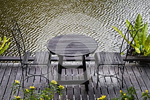 Two chairs and table on the backyard in tropical garden near lake with beautiful view