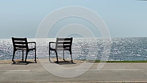 Two chairs of a tropical calm sea background