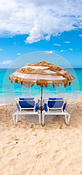 Two chairs and umbrella on beautiful tropical beach at St Maarten, Caribbean.