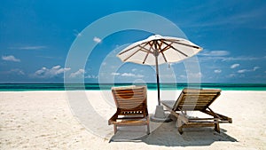 Two chairs and umbrella on idyllic beach on a tropical island, Maldives