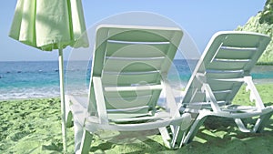 Two chairs and umbrella on stunning sandy beach