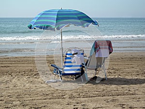 Two chairs under one umbrella