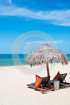 Two Chairs Under Parasol In Tropical Beach