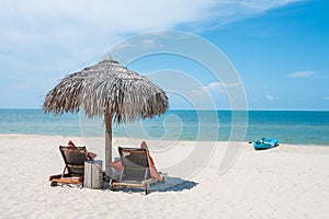 Two Chairs Under Parasol In Tropical Beach