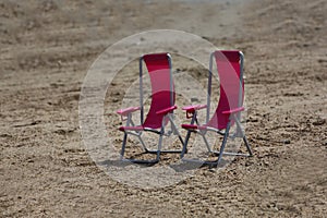 Two chaise longues on a sandy beach
