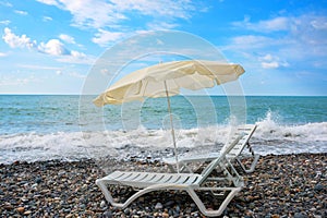 Two chaise lounges and a sunshade on the sea beach