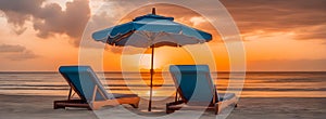 A two chaise lounges under an umbrella on the shore sandy beach, on a sunset background, beautiful orange clouds