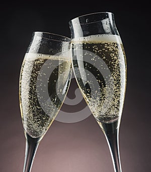 Two champagne glasses against bright lights