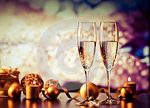 two champagne glasses against holiday lights and fireworks - new year celebration