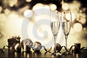 two champagne glasses against holiday lights and fireworks - new year celebration