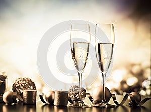 two champagne glasses against holiday lights and fireworks - new year celebration