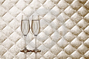 Two champagne glasses on blurred checkered background