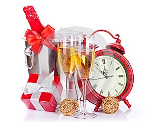Two champagne glasses, bottle in cooler and clock