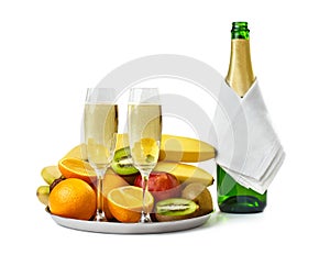 Two champagne glasses and bottle with fruits on the tray