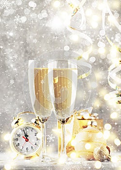 Two champagne glasses and christmas decoration over gray golden bokeh background. Happy New Year Celebration. Selective focus and