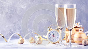 Two champagne glasses and christmas decoration over gray golden bokeh background. Happy New Year Celebration. Selective focus and