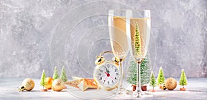 Two champagne glasses and christmas decoration over gray golden bokeh background. Happy New Year Celebration. Selective focus and