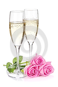 Two champagne glasses and pink rose flowers