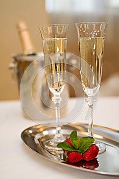 Two champaign glasses and strawberries on white