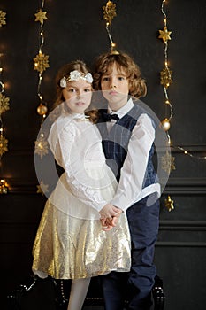 Two charming children stand having joined hands.