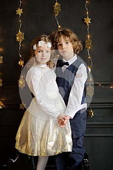 Two charming children stand having joined hands.