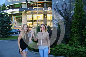 Two charming girl of European appearance hold hands and smiling,
