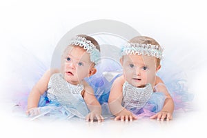 Two charming sisters baby twins in the lush beautiful dresses