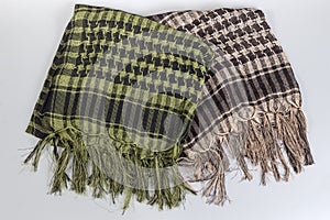 Two checkered variegated keffiyeh, partially folded on gray background photo