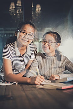 Two cheerful asian teenager studying in school class room happin