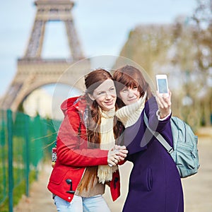 Two cheerful beautiful girls in Paris taking selfie