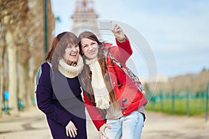 Two cheerful beautiful girls in Paris taking selfie