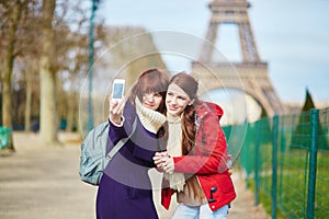 Two cheerful beautiful girls in Paris taking selfie