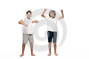 Two cheerful brothers listening music in headphones and dancing