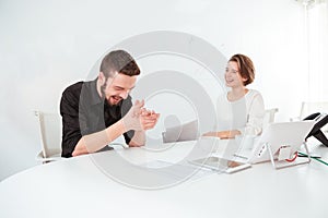 Two cheerful business people talking and laughing on meeting