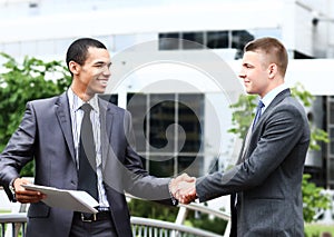 Two cheerful businessman handshaking